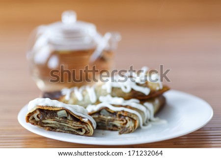 pancakes stuffed with mushrooms and cabbage with sour cream