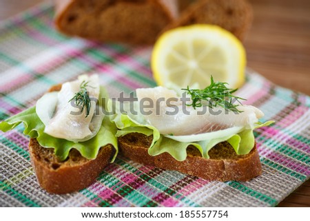 sandwich salted herring and lettuce  on a table