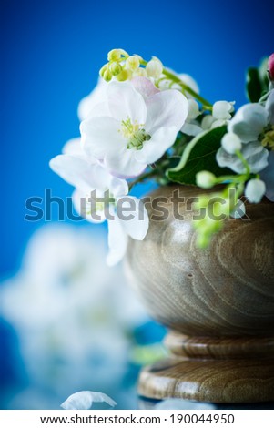 Spring bouquet of lily of the valley and apple blossom on a blue background