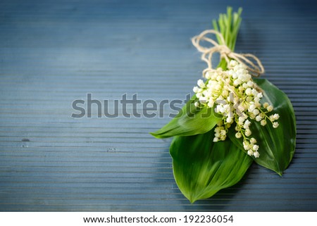 bouquet of lilies of the valley on a blue rustic table