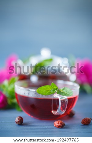 rosehip tea with fruits and flowers in a teapot on the table