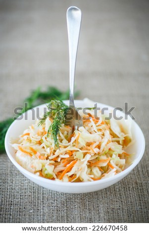 pickled cabbage and carrots in a white plate on the table