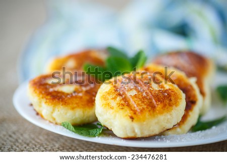 fried cheese fritters on a plate with icing sugar