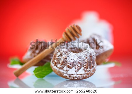 sweet honey muffins in powdered sugar on red background