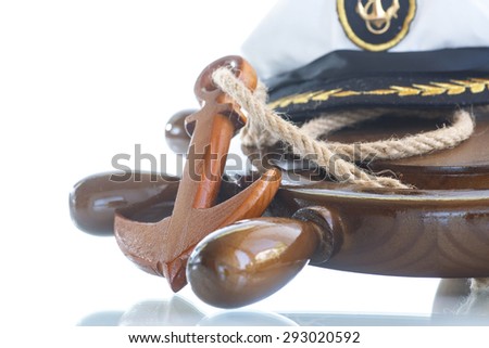 Decorative wooden ship anchored at the helm on a white background