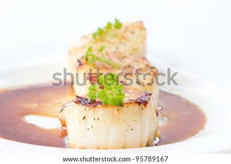 fried scallops with soy sauce on white plate