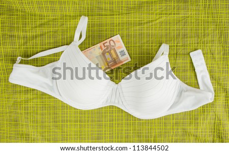 Lingerie with money on green bed sheets