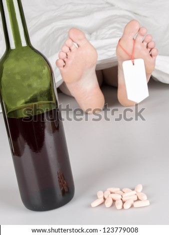 Dead body with toe tag, suicide by drug overdose and alcohol