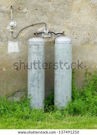 Gas bottles standing outside against a wall