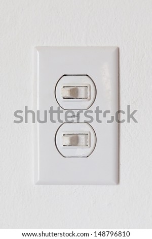 Close-up of an obsolete light-switches on a white wall