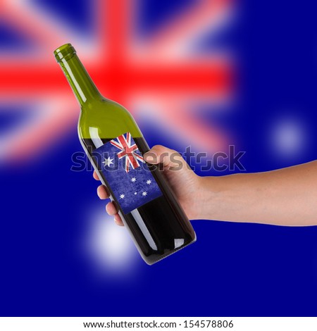 Hand holding a bottle of red wine, label of Australia, isolated on white,