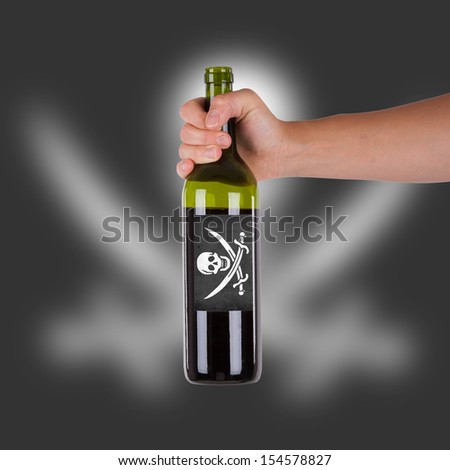 Hand holding a bottle of red wine, label of a pirate flag, isolated on white,