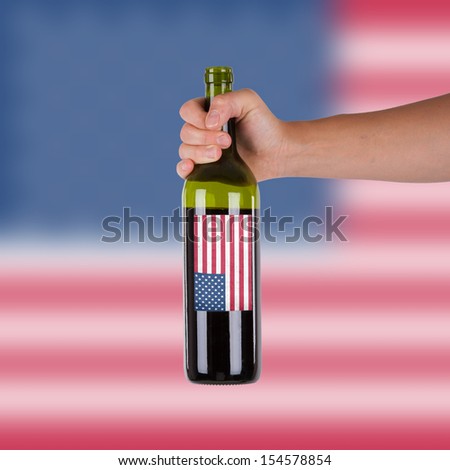 Hand holding a bottle of red wine, label of the United States, isolated on white,