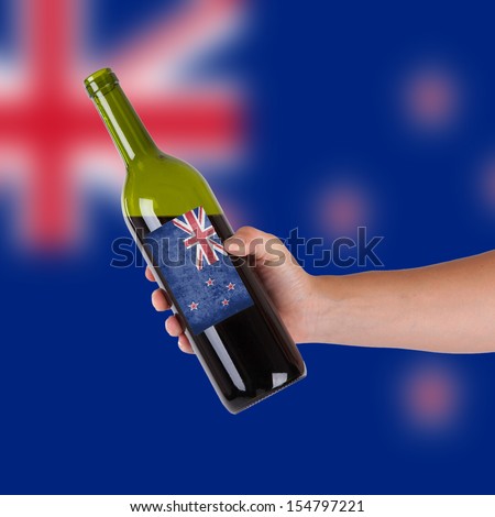 Hand holding a bottle of red wine, label of Australia, isolated on white