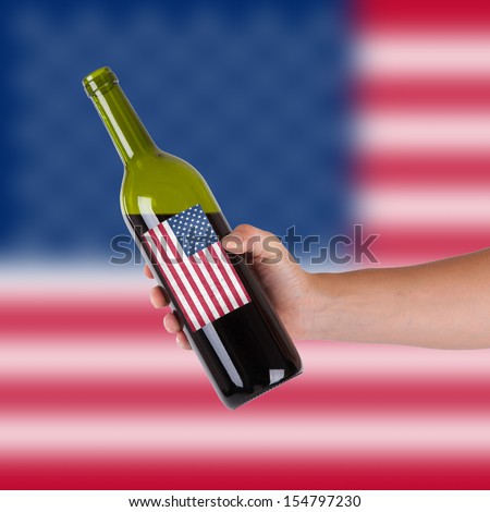 Hand holding a bottle of red wine, label of the United States, isolated on white,