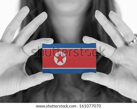 Woman showing a business card, black and white, North Korea