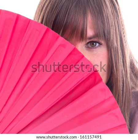 Studio portrait of a womans face partly hidden by a fan, isolated on white