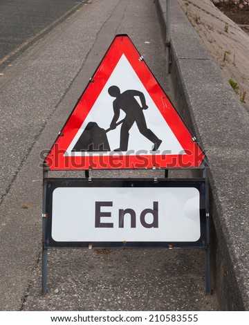 Triangular construction sign standing on footpath, end of construction
