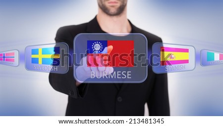 Hand pushing on a touch screen interface, choosing language or country, Myanmar