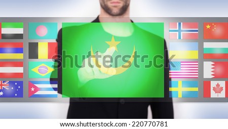 Hand pushing on a touch screen interface, choosing language or country, Mauritania