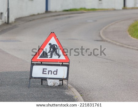 Triangular construction sign standing on footpath, selective focus, end of construction