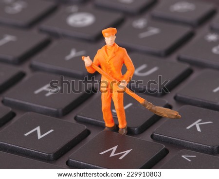 Miniature worker is cleaning a computer keyboard