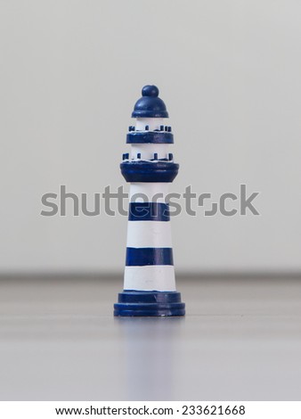 Blue and white striped lighthouse isolated over white