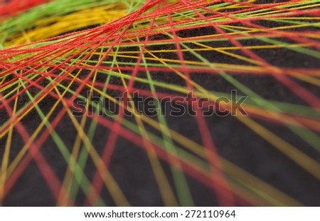 Display of colorful threads on a black panel