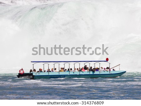 RHEINFALLS, SWITZERLAND - JULY 25, 2015:Boat with tourists at the biggest waterfalls of Europe in Schaffhausen, Switzerland. They are 150 m (450 ft) wide and 23 m (75 ft) high on july 25, 2015.