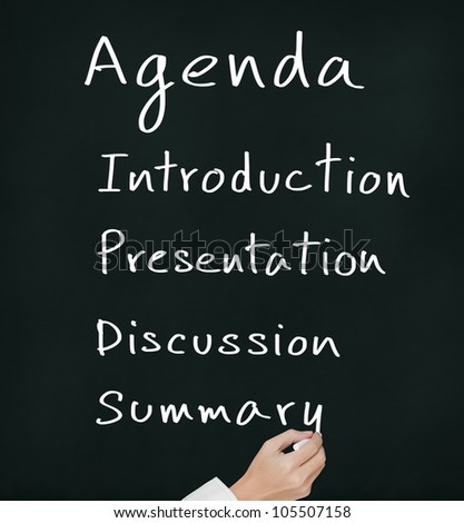 business hand writing meeting agenda on chalkboard