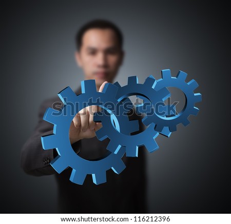 business man pointing at set of gears, concept of industry, machine, teamwork, power, and advance