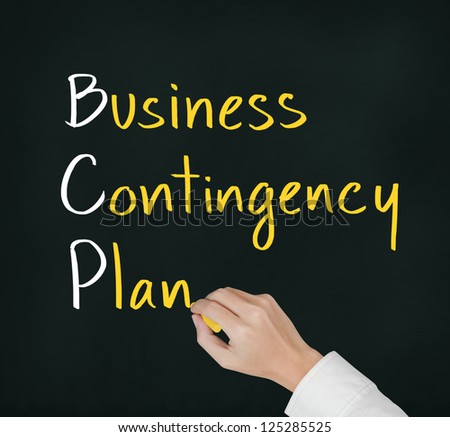 business hand writing business contingency plan