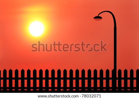 silhouette of lamppost and wood fence during sunset