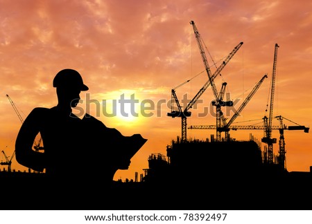 silhouette of a man working on construction site in the morning