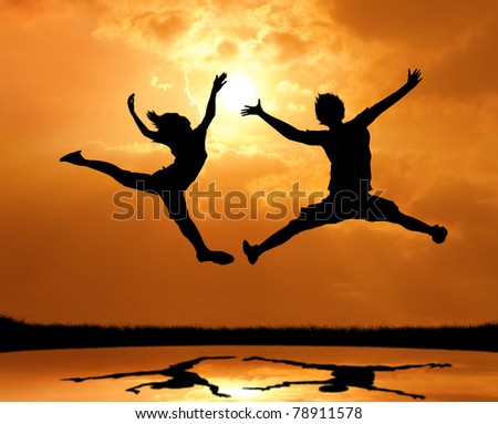 silhouette of man and woman jumping and touch the sun