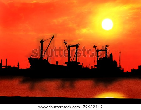 industrial ship and factory silhouetted at sunset