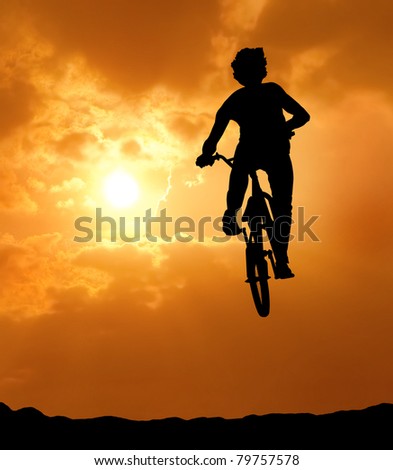 silhouette of man jumping with bicycle at sunset