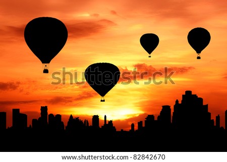 group of hot air balloon fly over city at sunset silhouetted