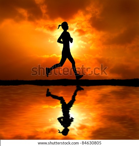 healthy young woman running aside the beach at sunset silhouetted