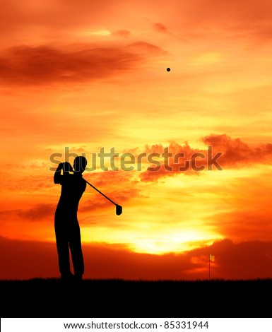 male golfer hit golf ball toward the hole at sunset silhouetted