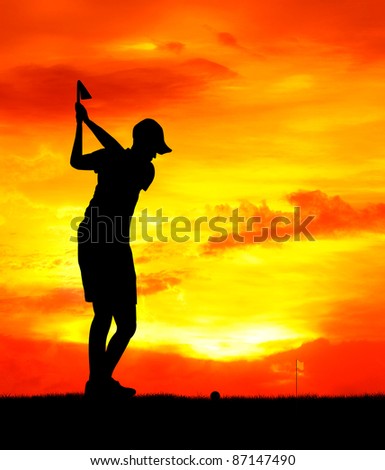 male golfer aim at golf ball at sunset silhouetted