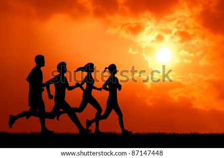 healthy man and woman group running at sunset silhouetted