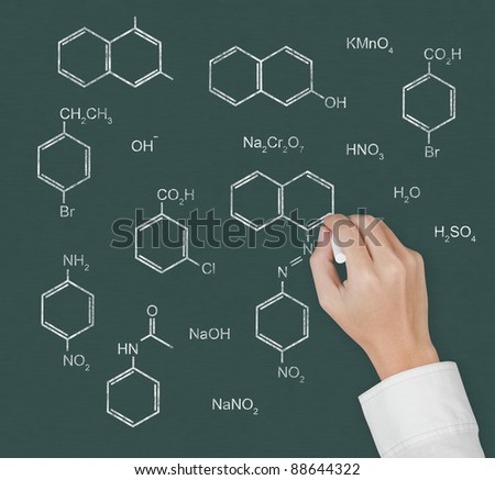 chemistry teacher hand writing scientific  formula of chemical on chalkboard