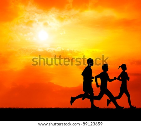 running group of healthy man and woman at sunset silhouetted