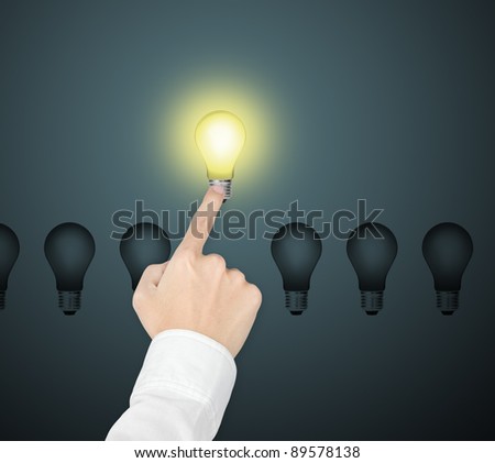 outstanding bright light bulb symbol of leading idea being pointed by male hand
