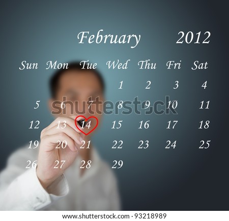 business man writing red heart mark at valentine day on calendar