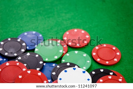 Poker chips on green background. Room for text. Shallow DOF.