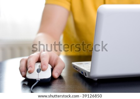 Man in yellow shirt with his right hand on the mouse (shallow DOF)