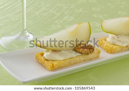 Two canapÃ?Â© with blue chees, slice of pear and walnut