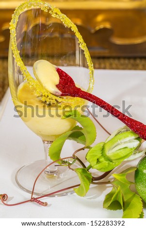 Passion fruit mousse with red spoon and fresh green and yellow passion fruit